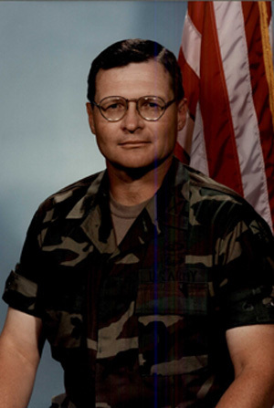 Headshot of LTC Michael Edwards with a light grey and an American flag in background