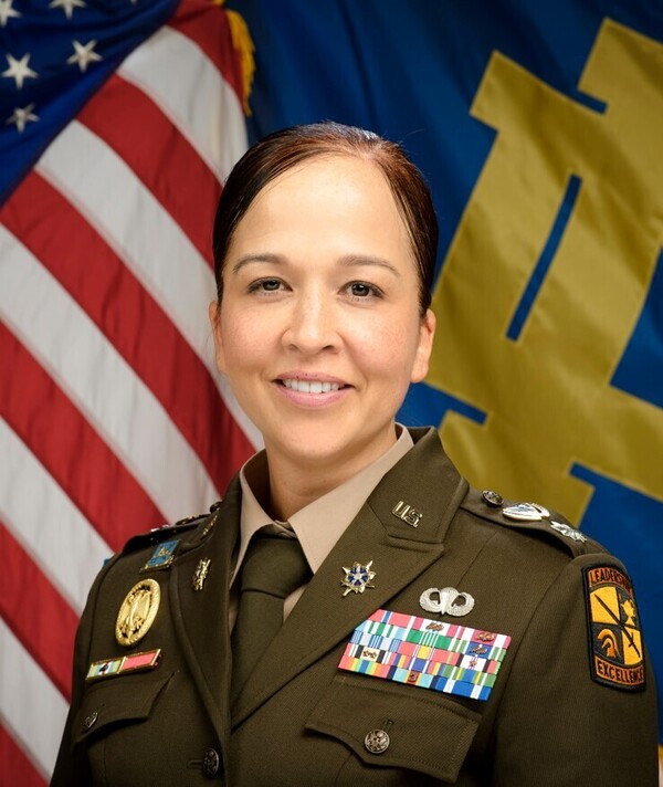 Headshot of COL Nora Flott with American flag and Notre Dame flag in background