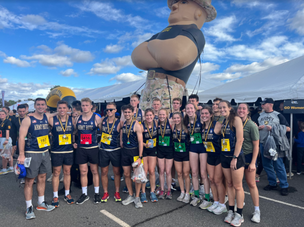 Running club poses with large inflatable Army soldier before a race