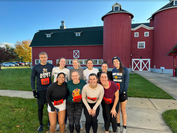 10 of the Running club members pose for a photo in front of a red barn